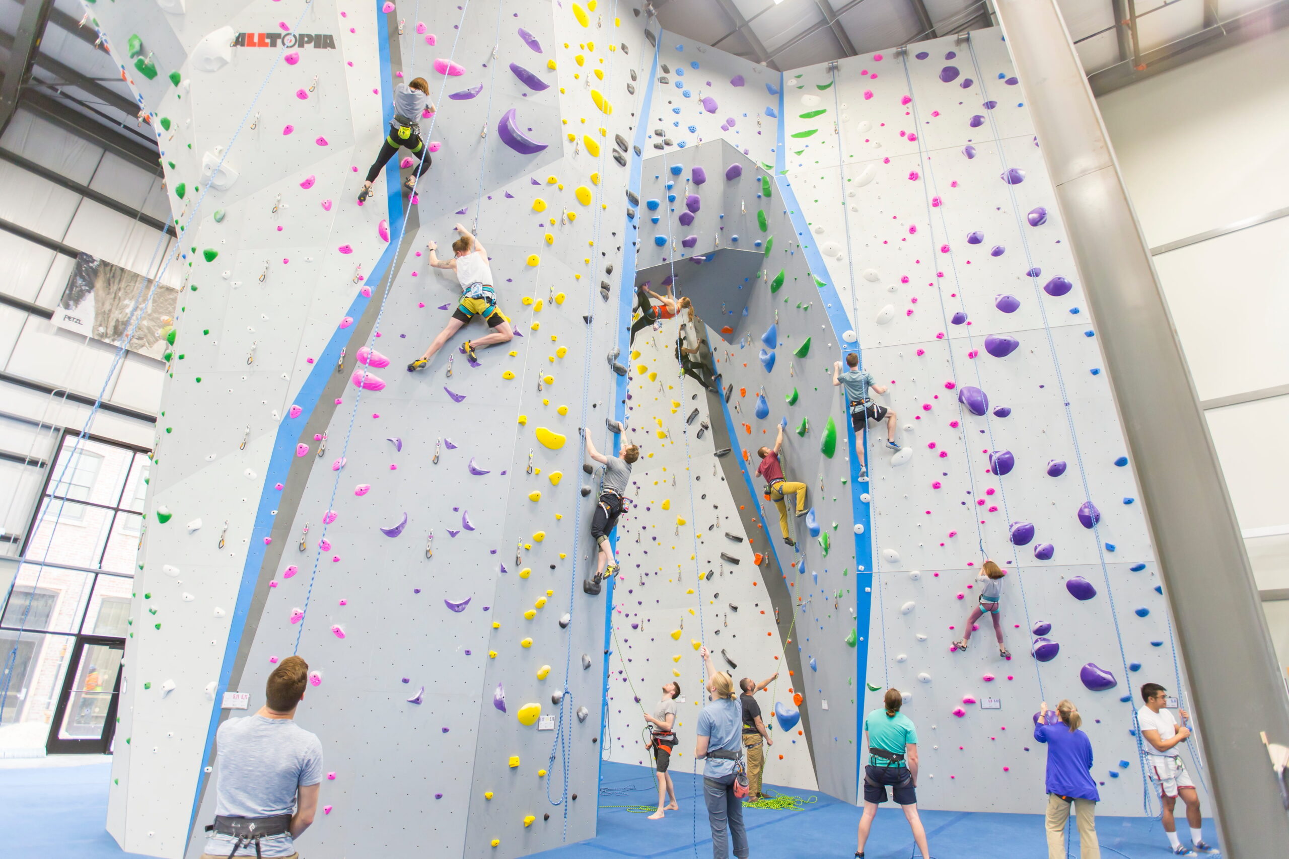 Several climbers are leading and top rope climbing on an archway.