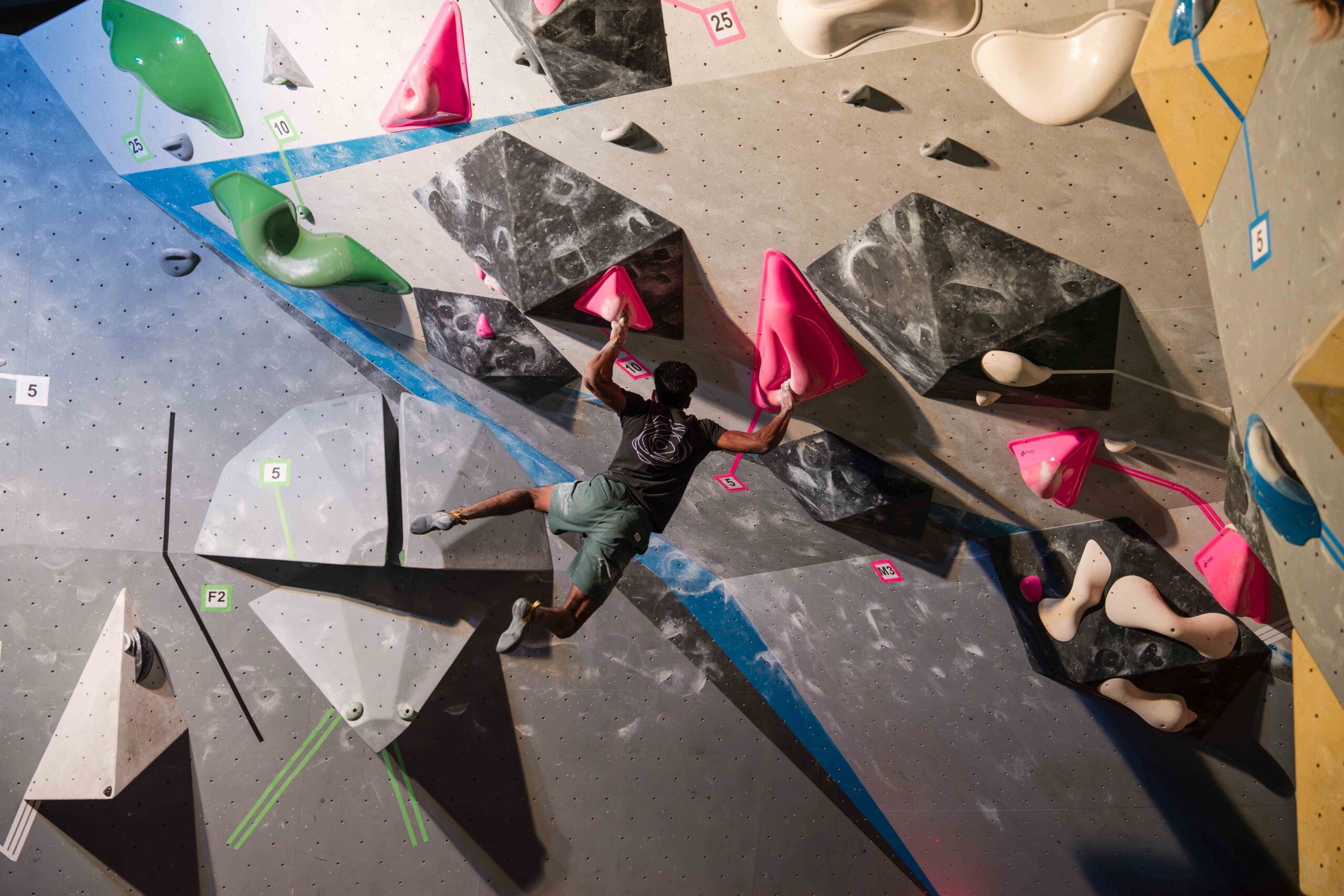 a man is hanging while bouldering at Central rock gym