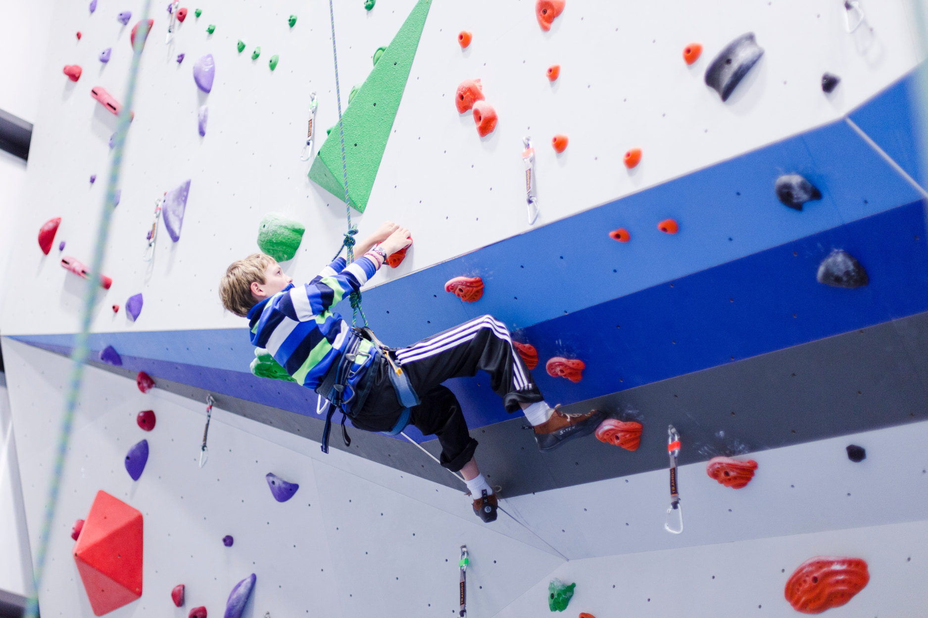 A young boy top rope climbs during a CRG youth program