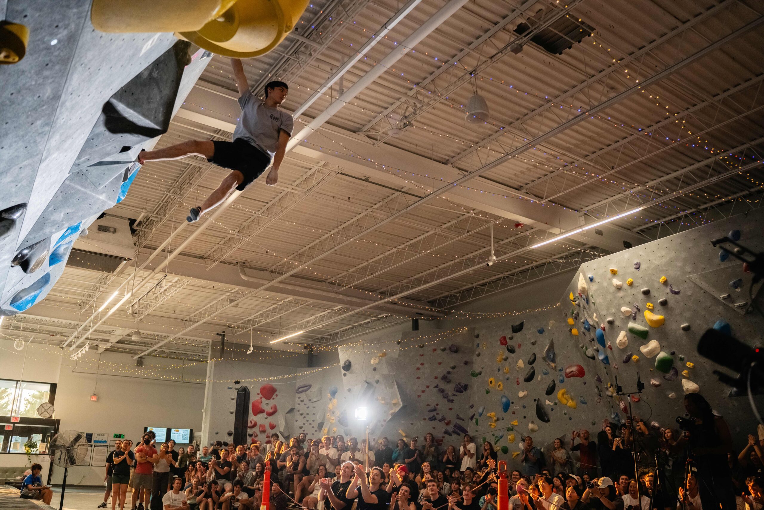 Competition finalist grabs finish hold and faces an excited crowd.
