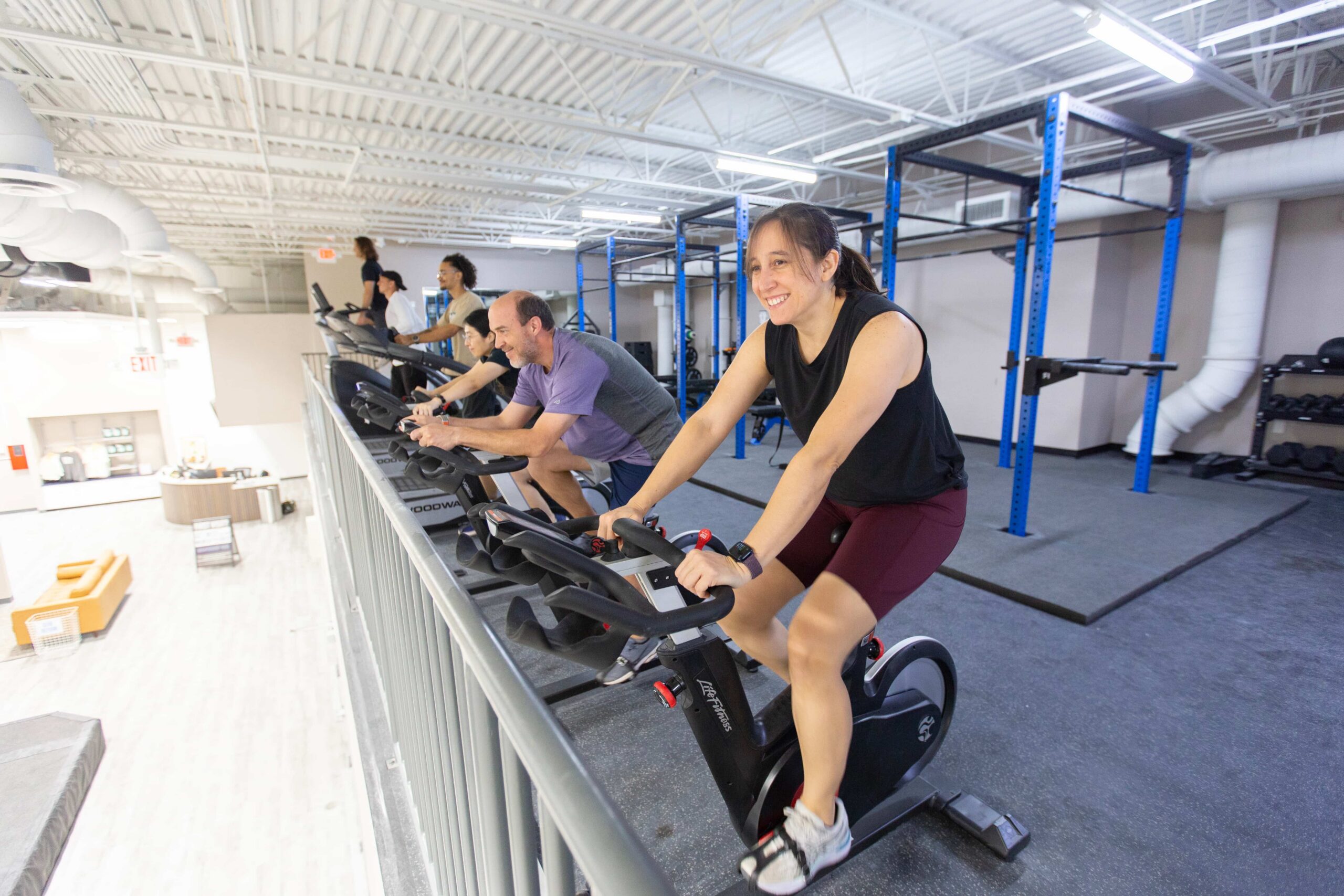 Climbers workout on cardio equipment: bikes, treadmills, and a stair stepper.