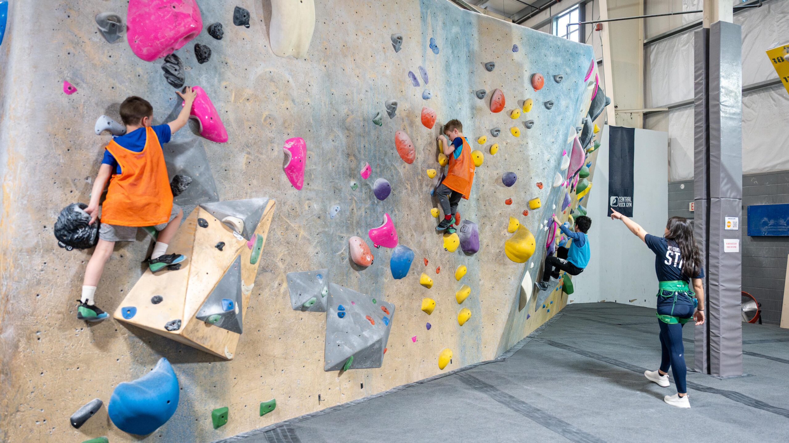 Kids at Summer Camp bouldering with guidance from a coach.