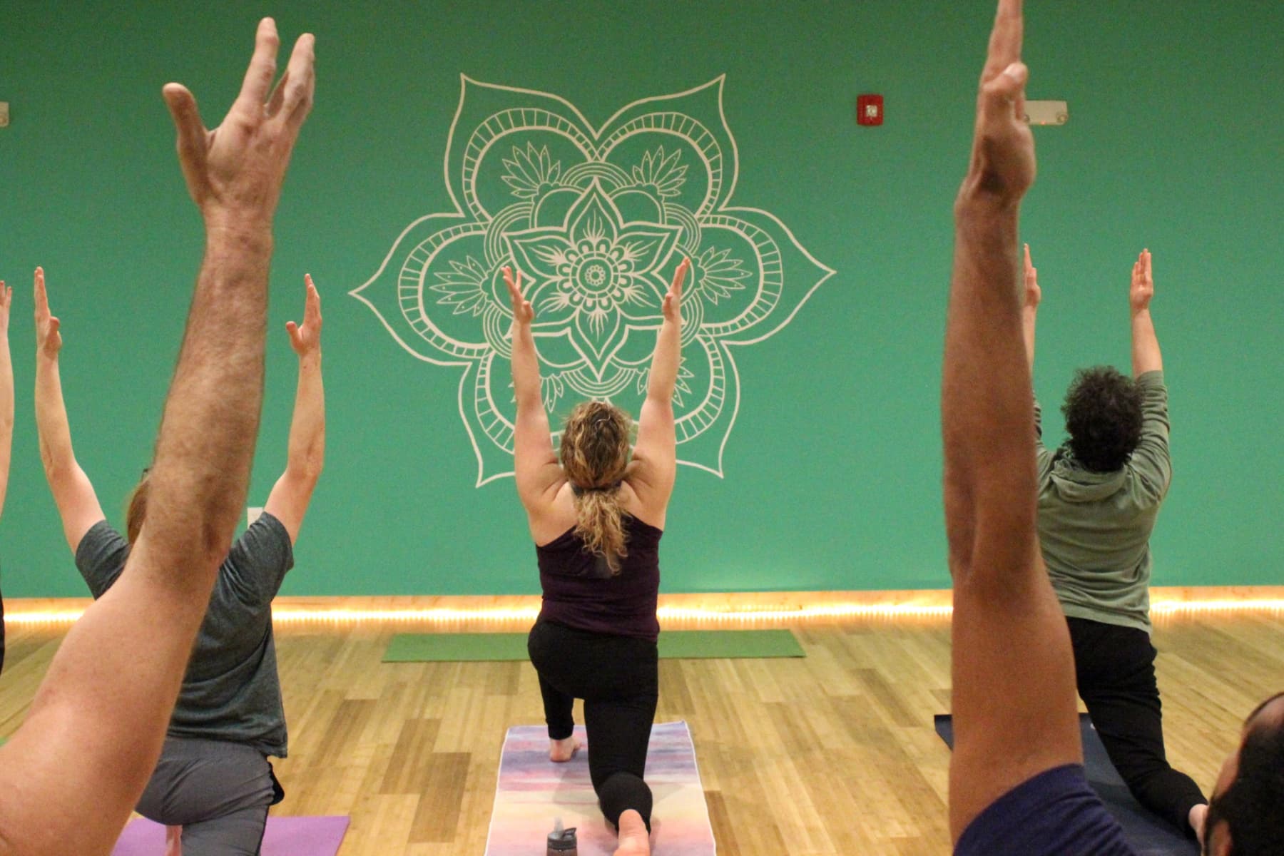 Image of Yoga class in crescent lunge at Central Rock Gym in Hadley.
