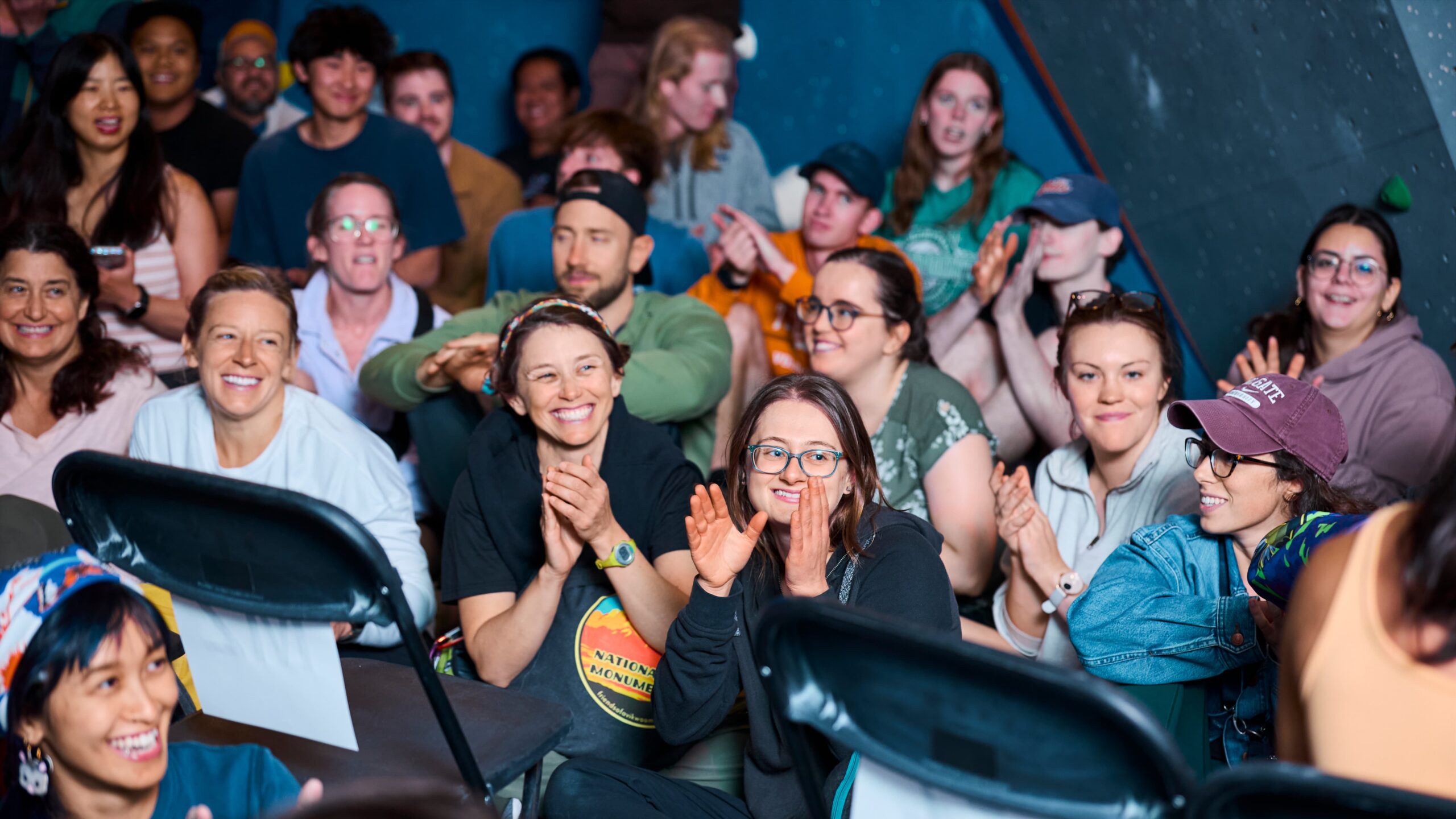 Community event at Central Rock Gym North Station — a crowd of climbers and guests cheer and clap together at an indoor rock climbing event in Boston, MA