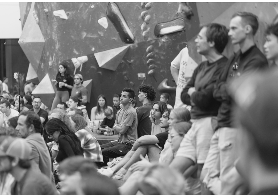 A crowd of people sit and intently watch a bouldering competition at Central Rock Gym Orlando.