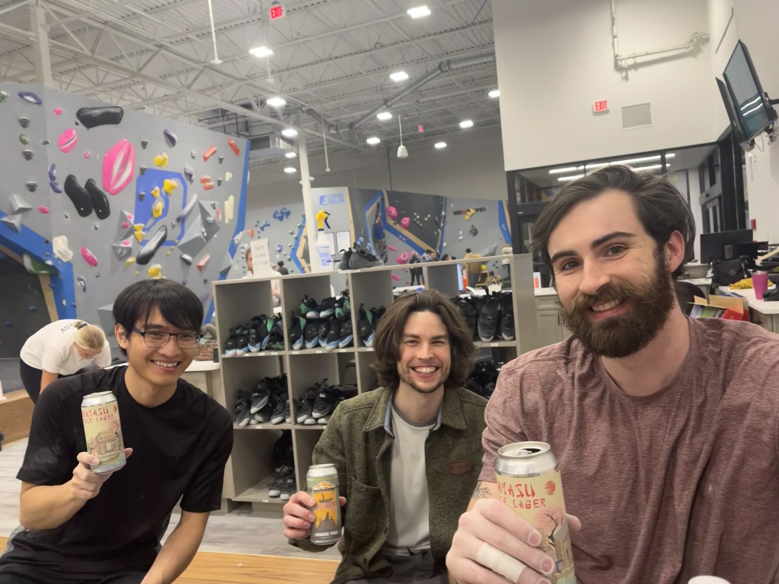 three people holding drinks during boulders and brews