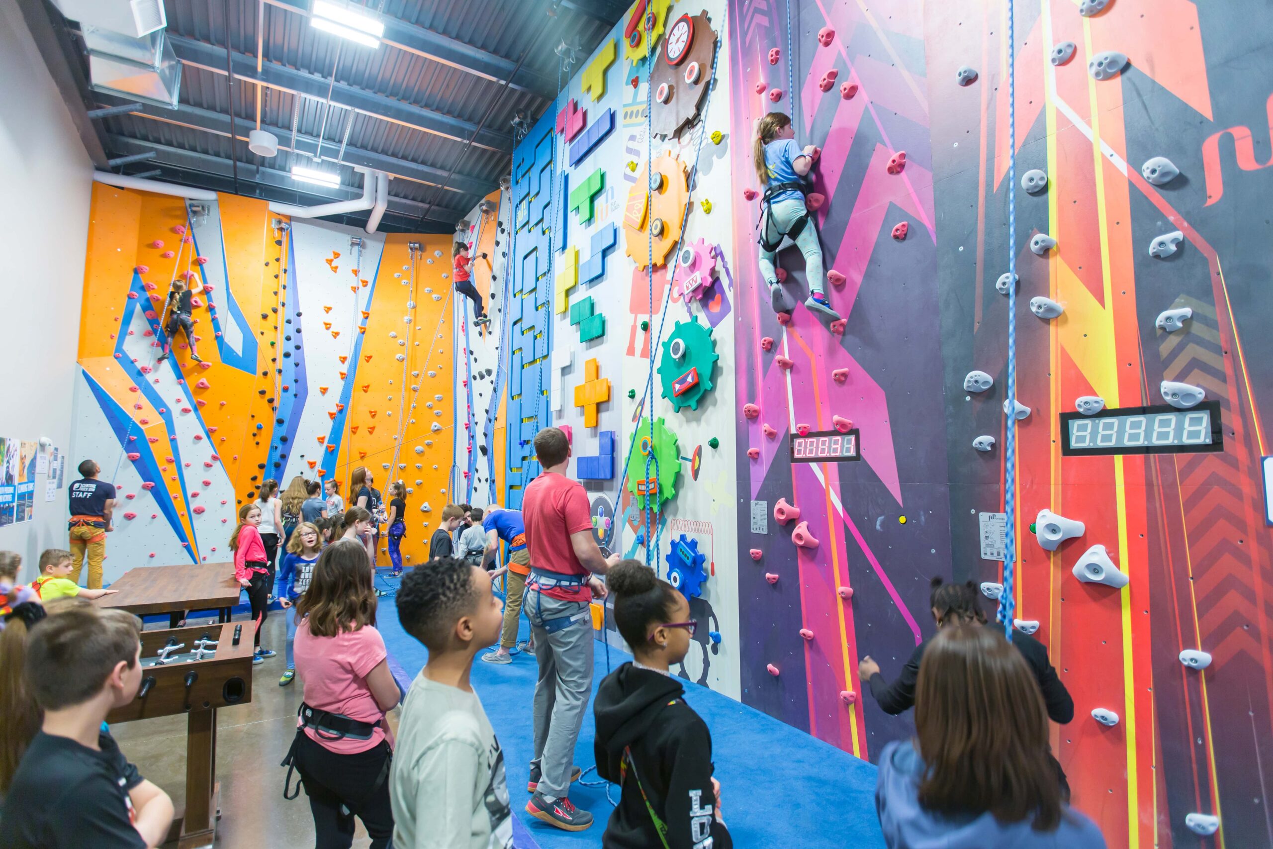 A group of kids climb in a kids area with shorter walls.