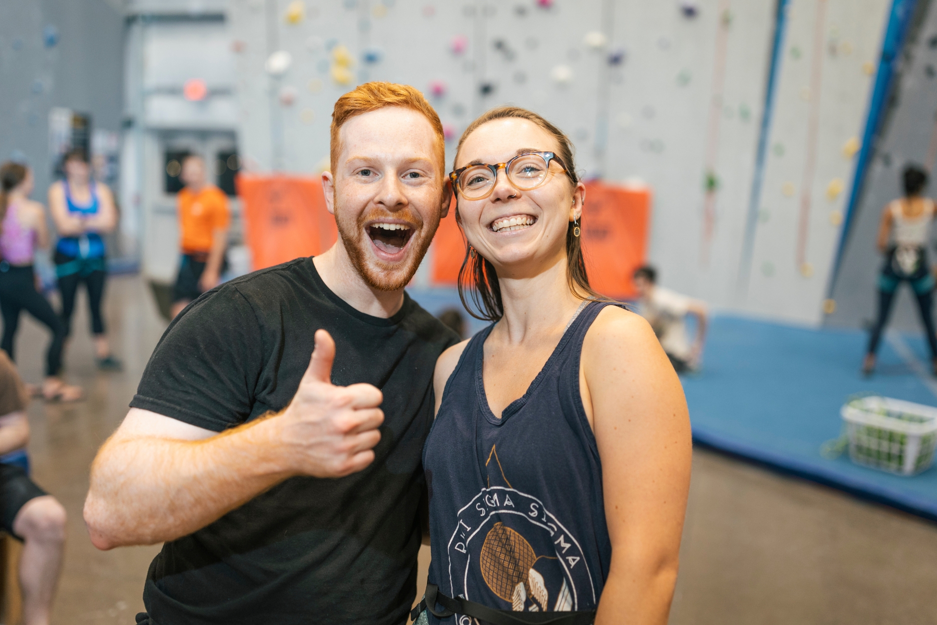 Two friends enjoying their time in the gym, with a thumbs up.