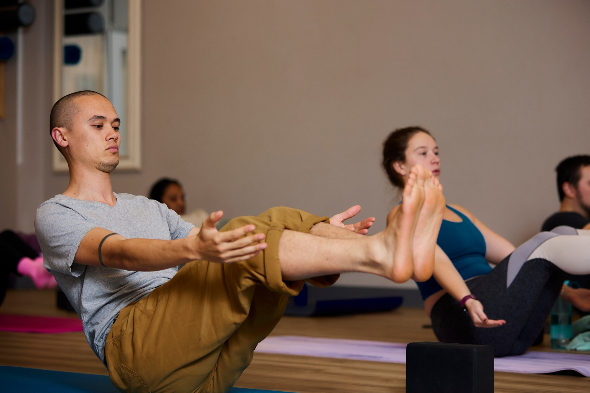 Man holding yoga pose in class.