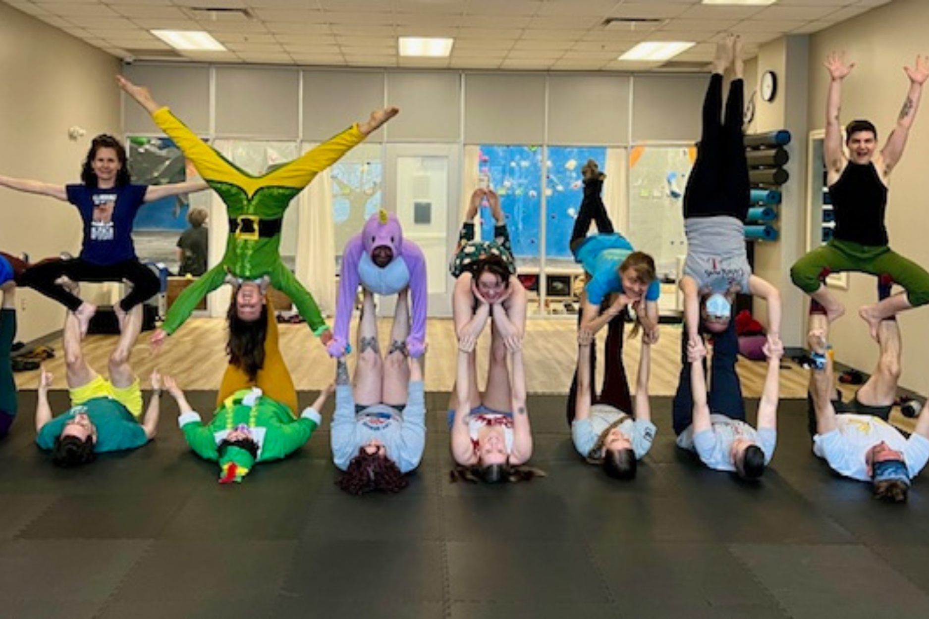 Group holding acro yoga pose during class.