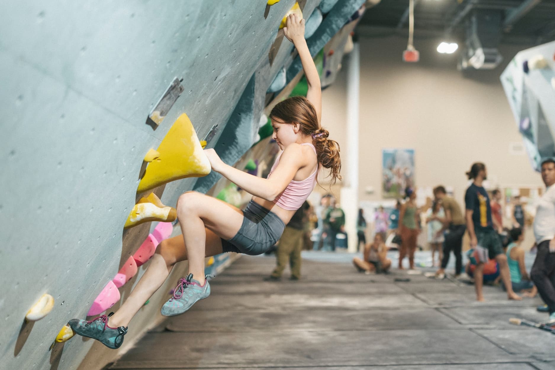 Girl bouldering on an overhanging wall