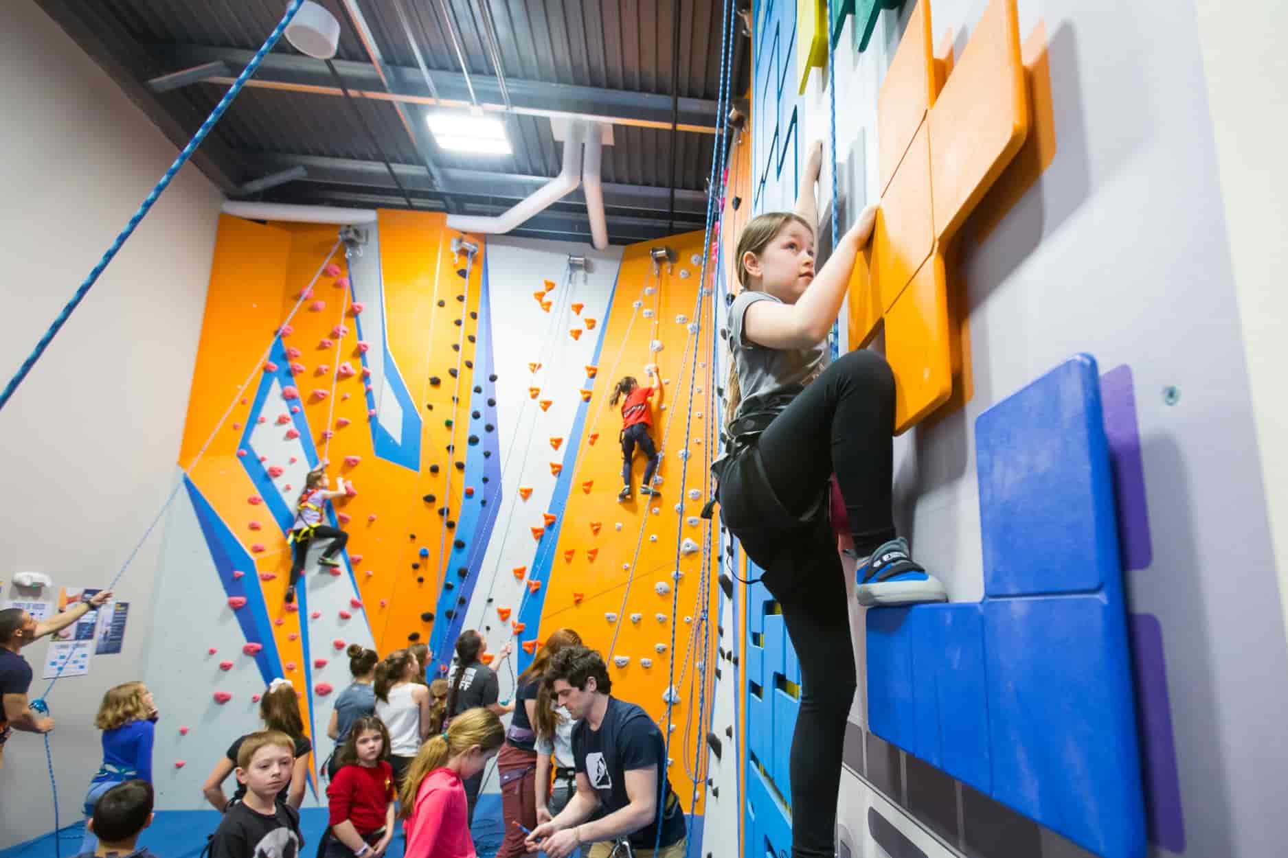 Young climbers climbing on top rope in the kids climbing area