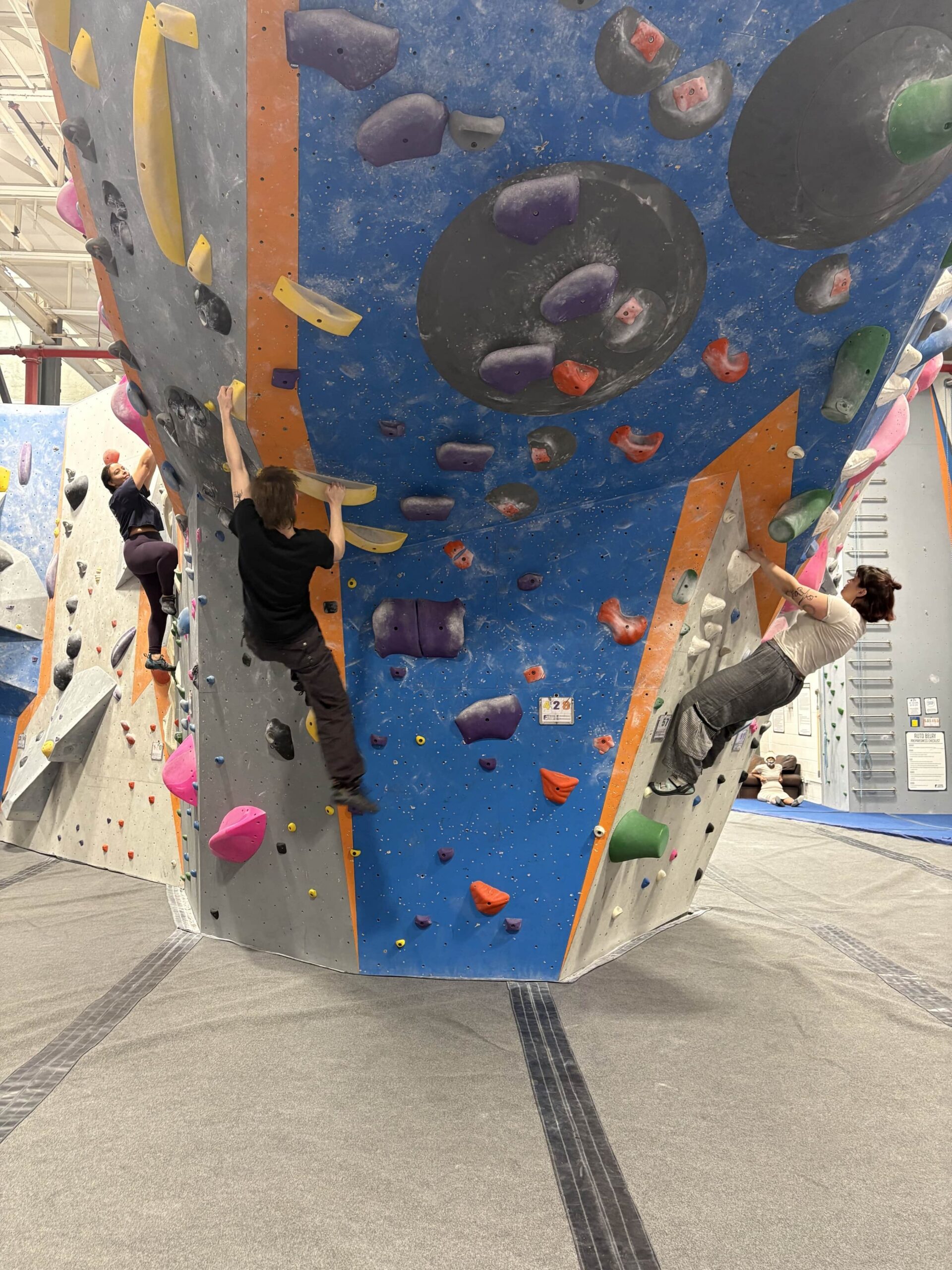 Three women bouldering on the Steep (overhung section) of the wall.