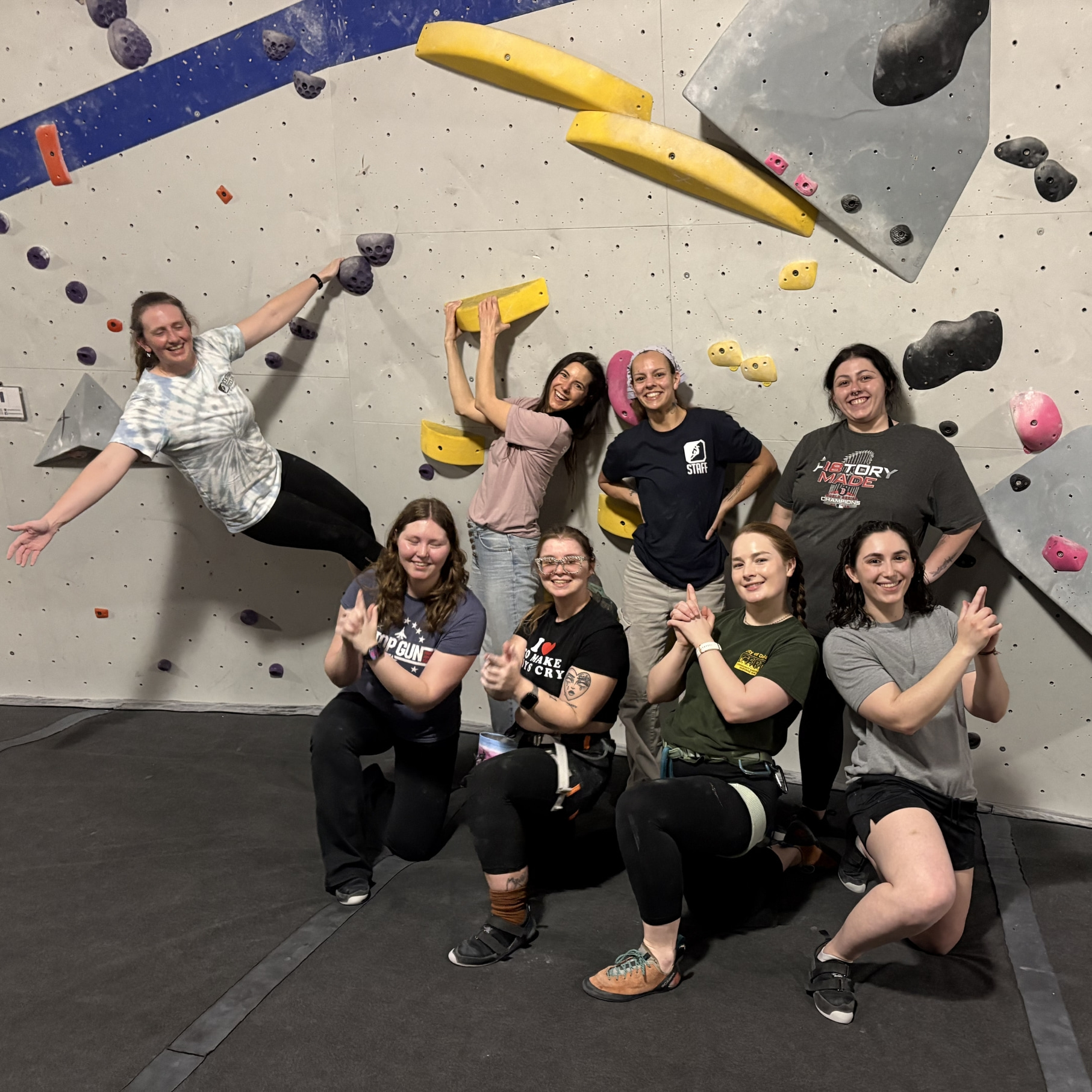 Women climbers posing on a boulder wall, following a women's climbing night event.