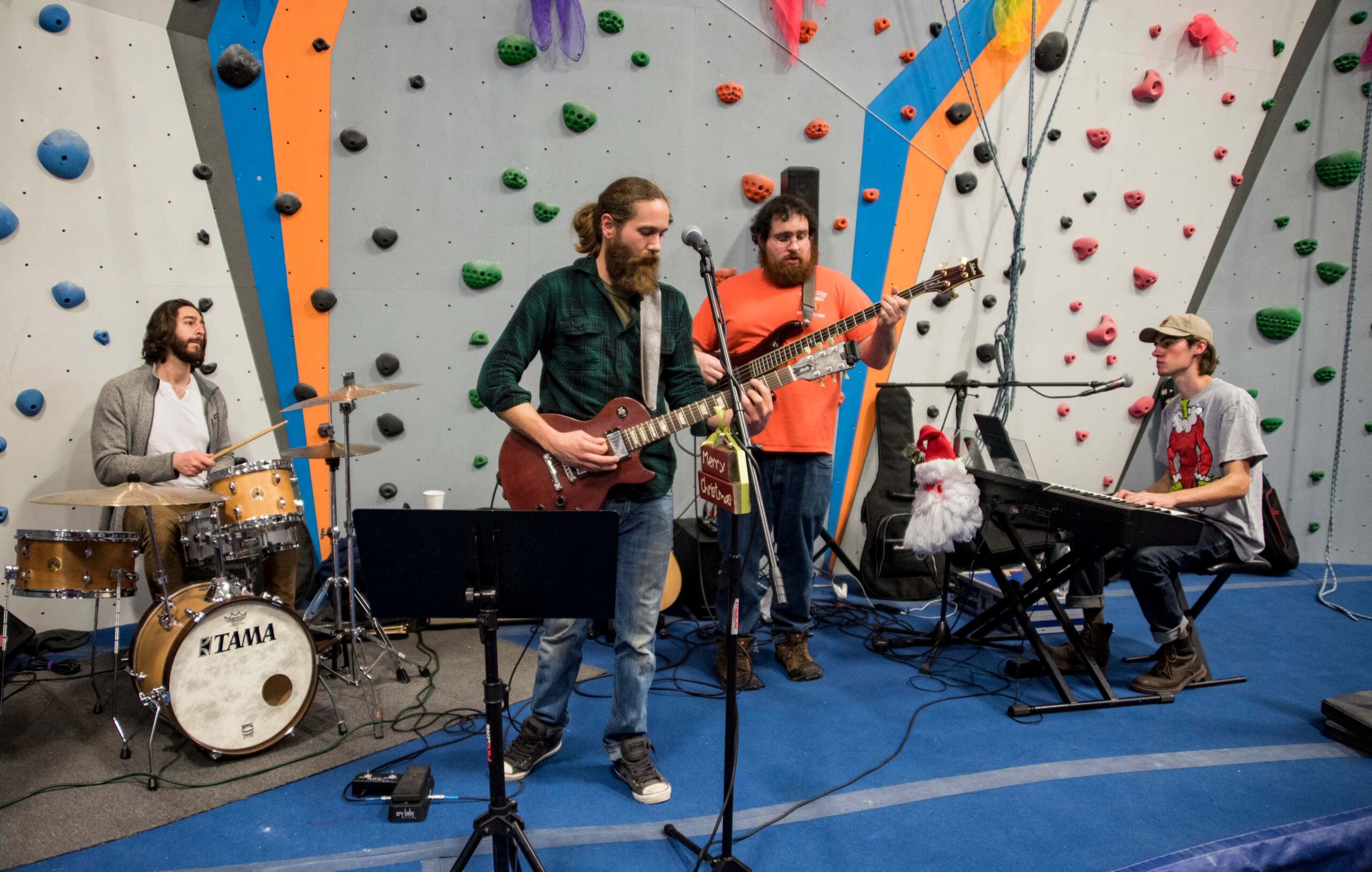 A local band plays music in the middle of the climbing gym.