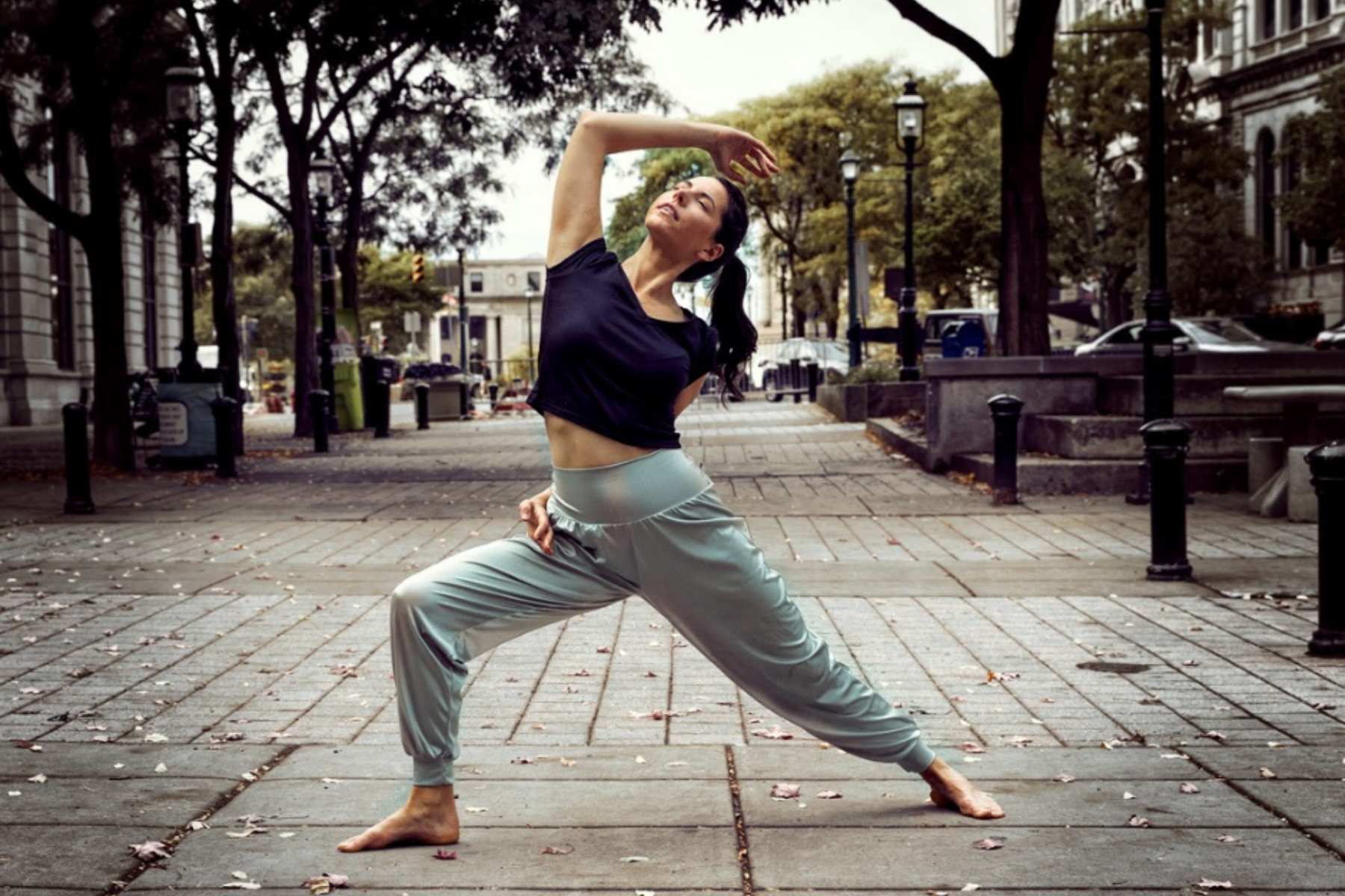 Yoga instructor in reverse warrior 2 with arm bind.