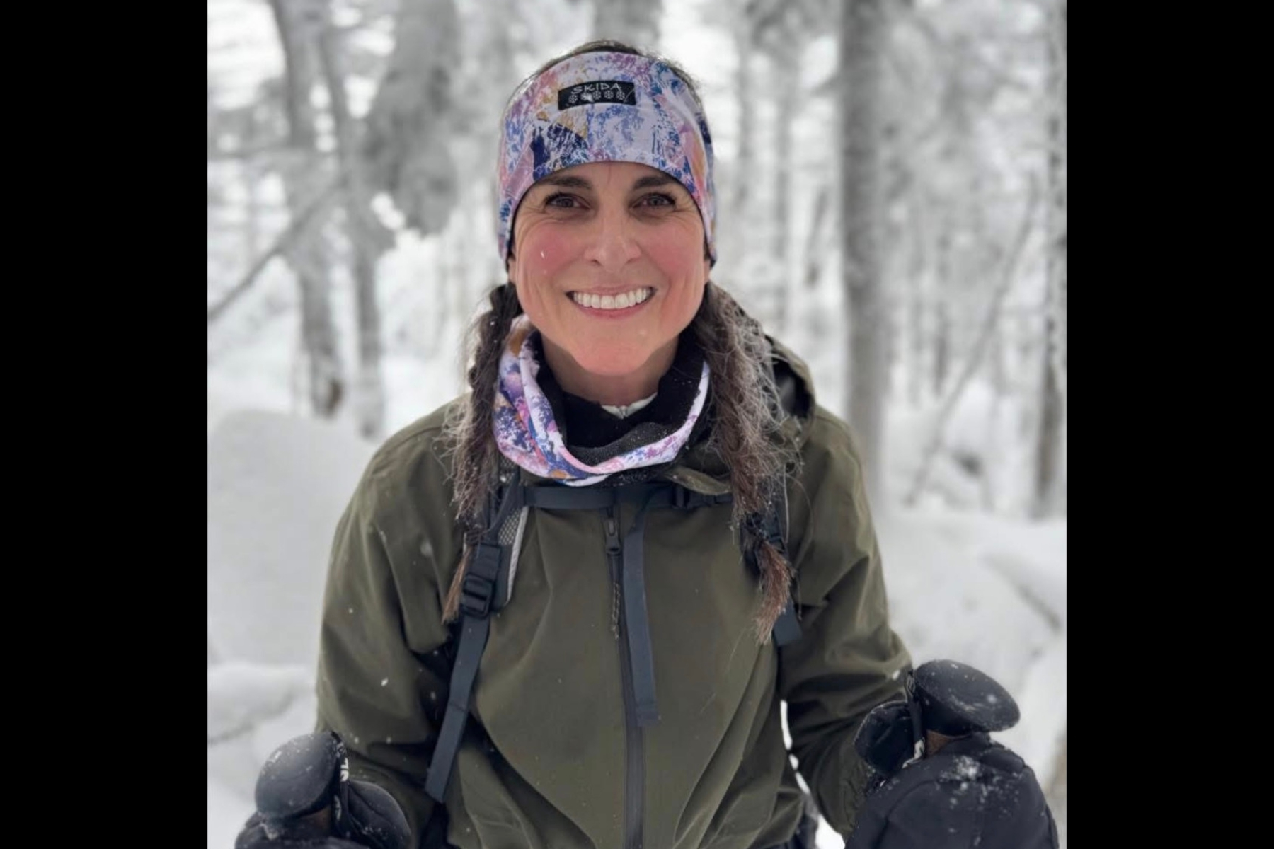 Smiling fitness instructor outside in a winter wonderland.