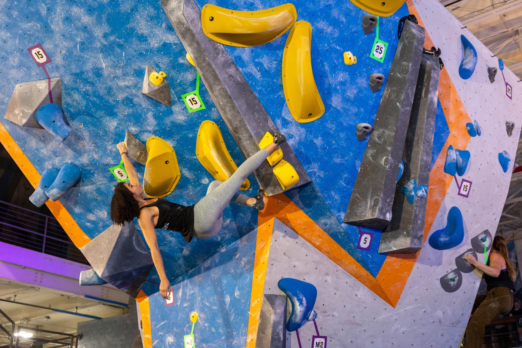 Two female finalists climbing boulders at the 2025 Salt City Showdown.