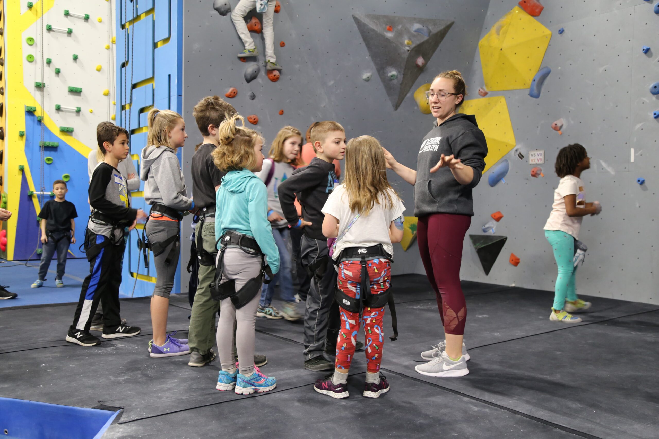 A group of children listening to their teacher in a climbing gym
