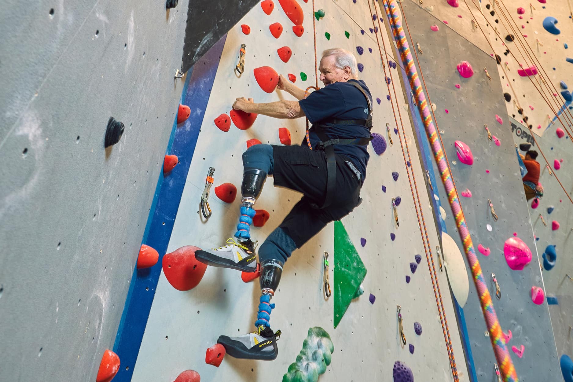 a old man is top rope climbing at central rock gym