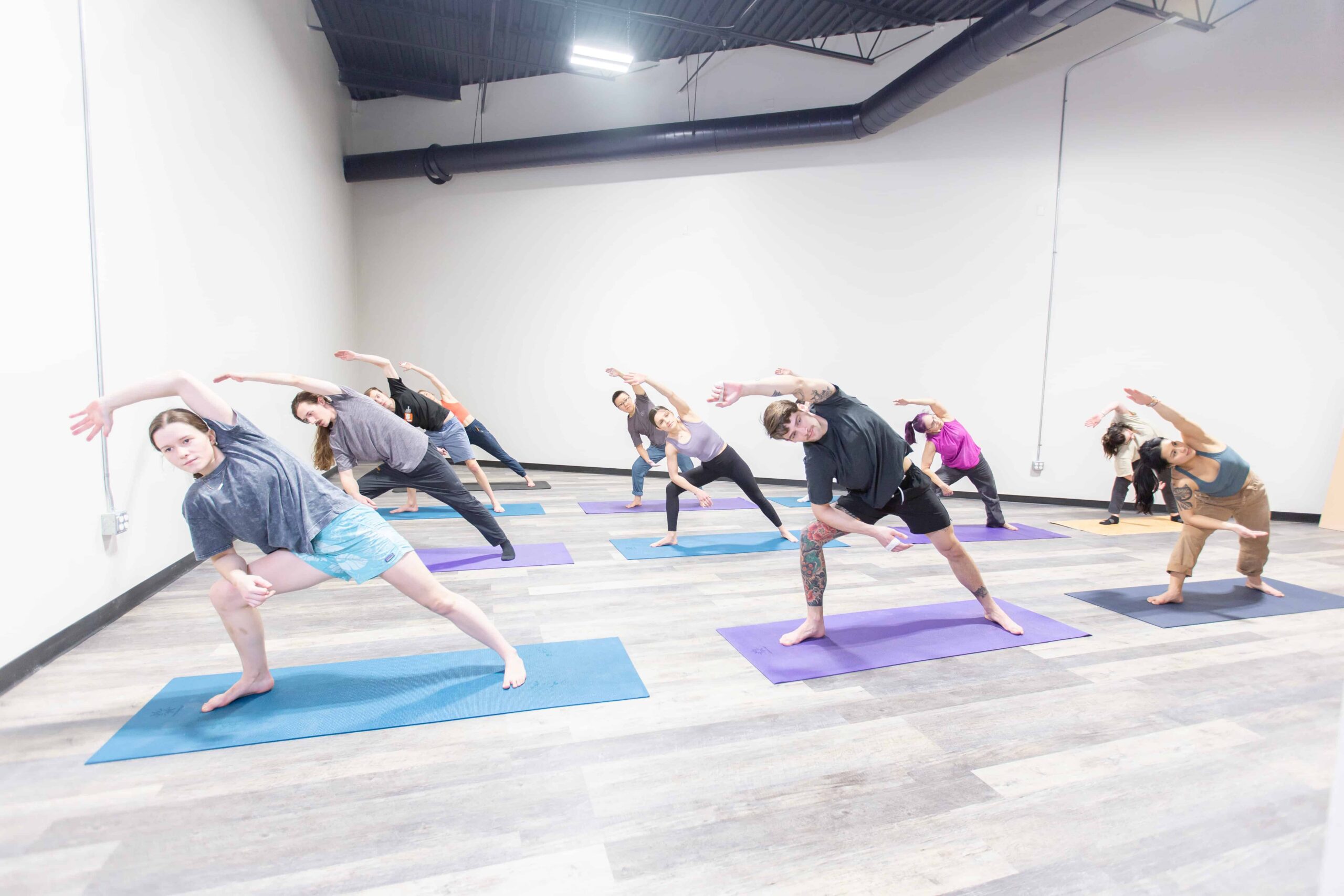 A class holds a yoga pose.