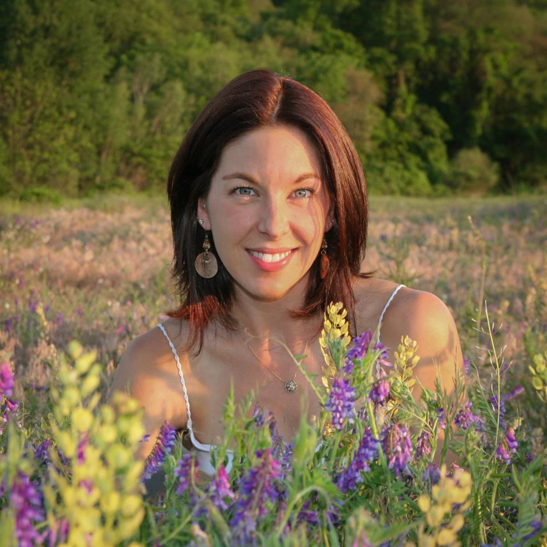 Picture of CRG Worcester's Breathwork and Hatha Yoga Instructor, Kristin, in a field of flowers.