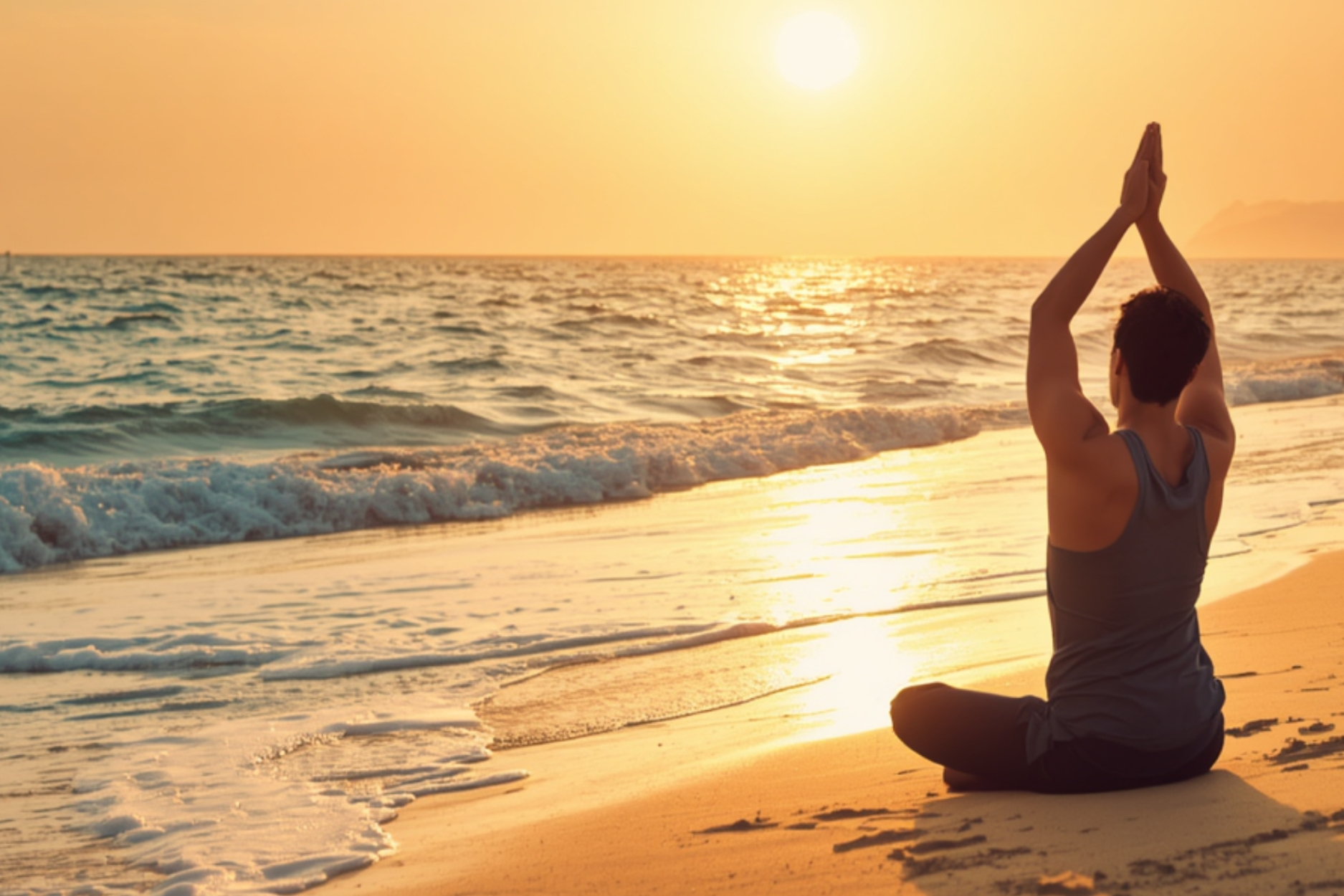 This is a picture of a man practicing yoga on a beach during a sunset to represent refresh and renew yoga.