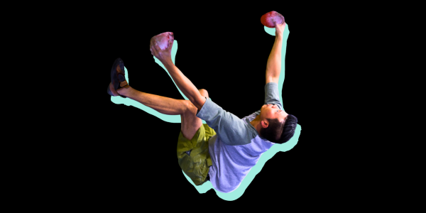 A man is bouldering on a overhung wall and looking toward his next move.