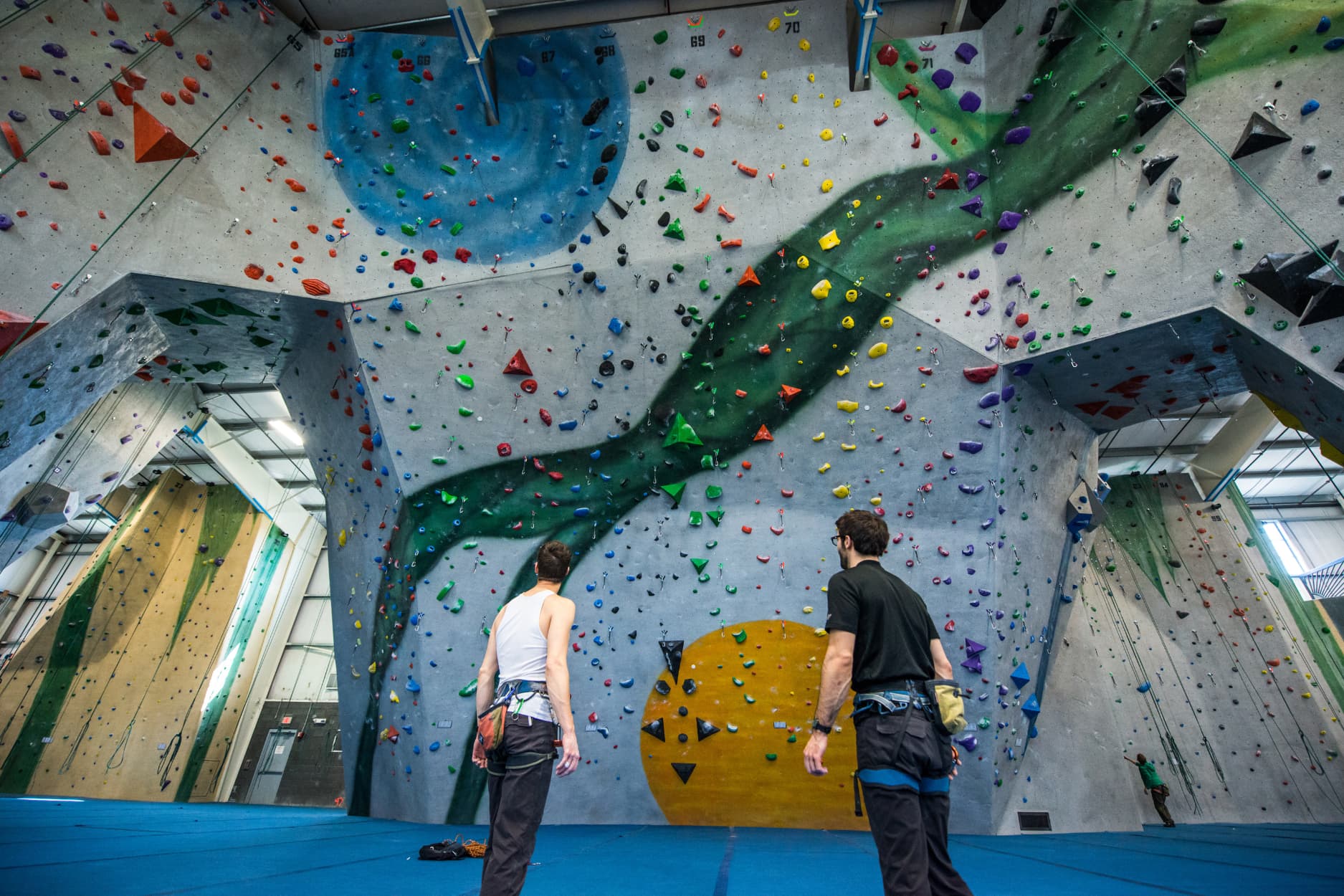 Two men stand and look at an awe inspiring lead climbing cave sandwiched between two climbing arches.