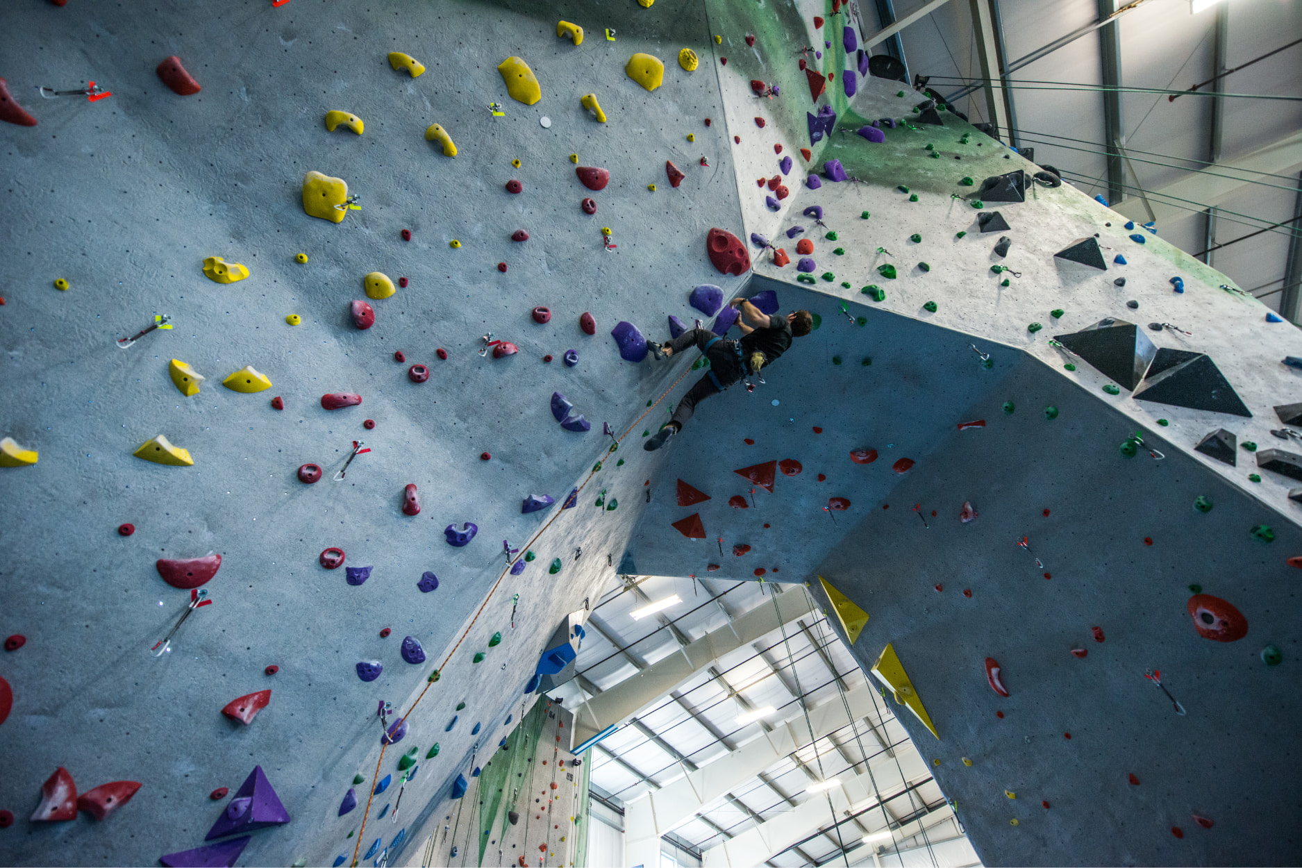 A man lead climbs on an archway at Central Rock Gym.