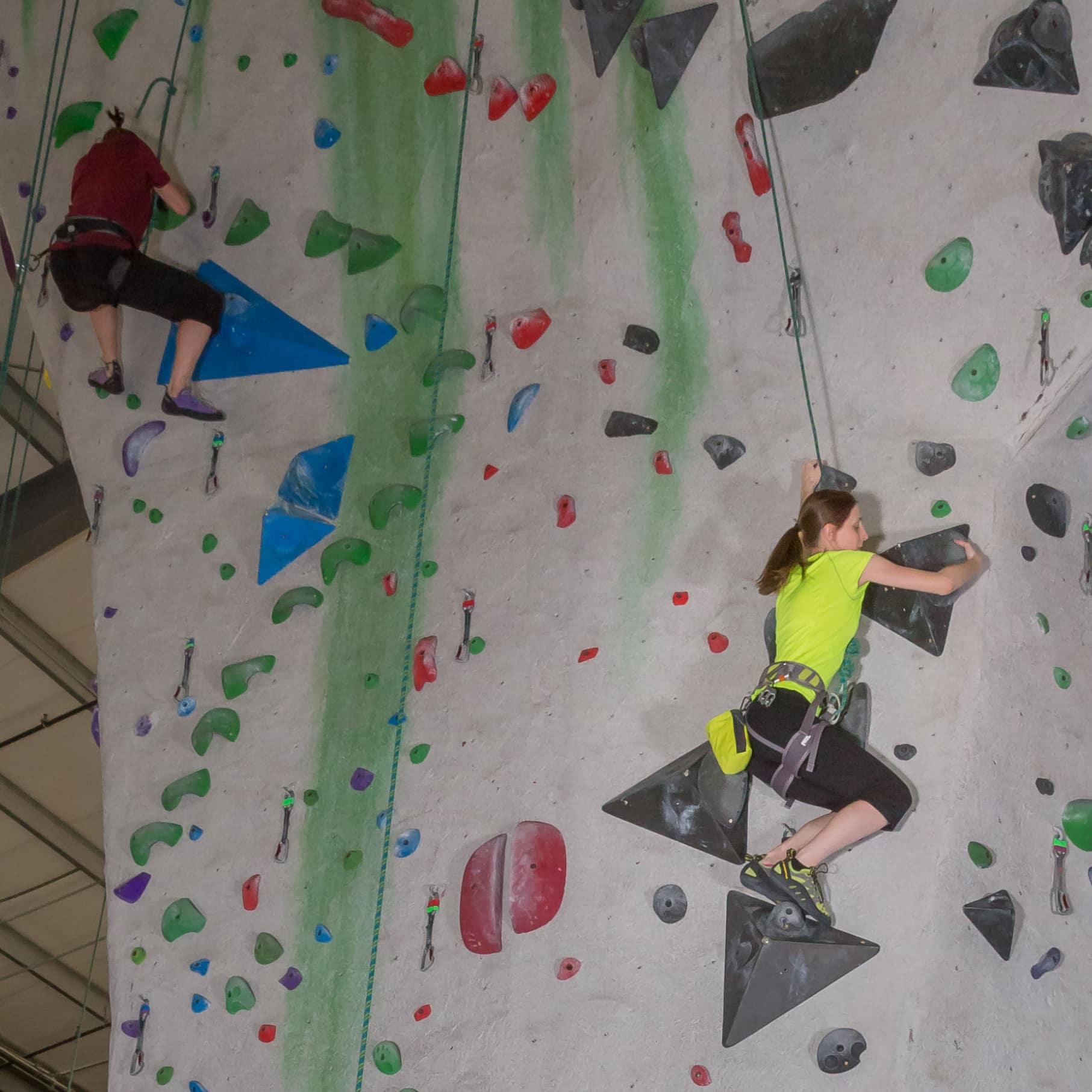Two women are top rope climbing at Central Rock Gym Worcester.