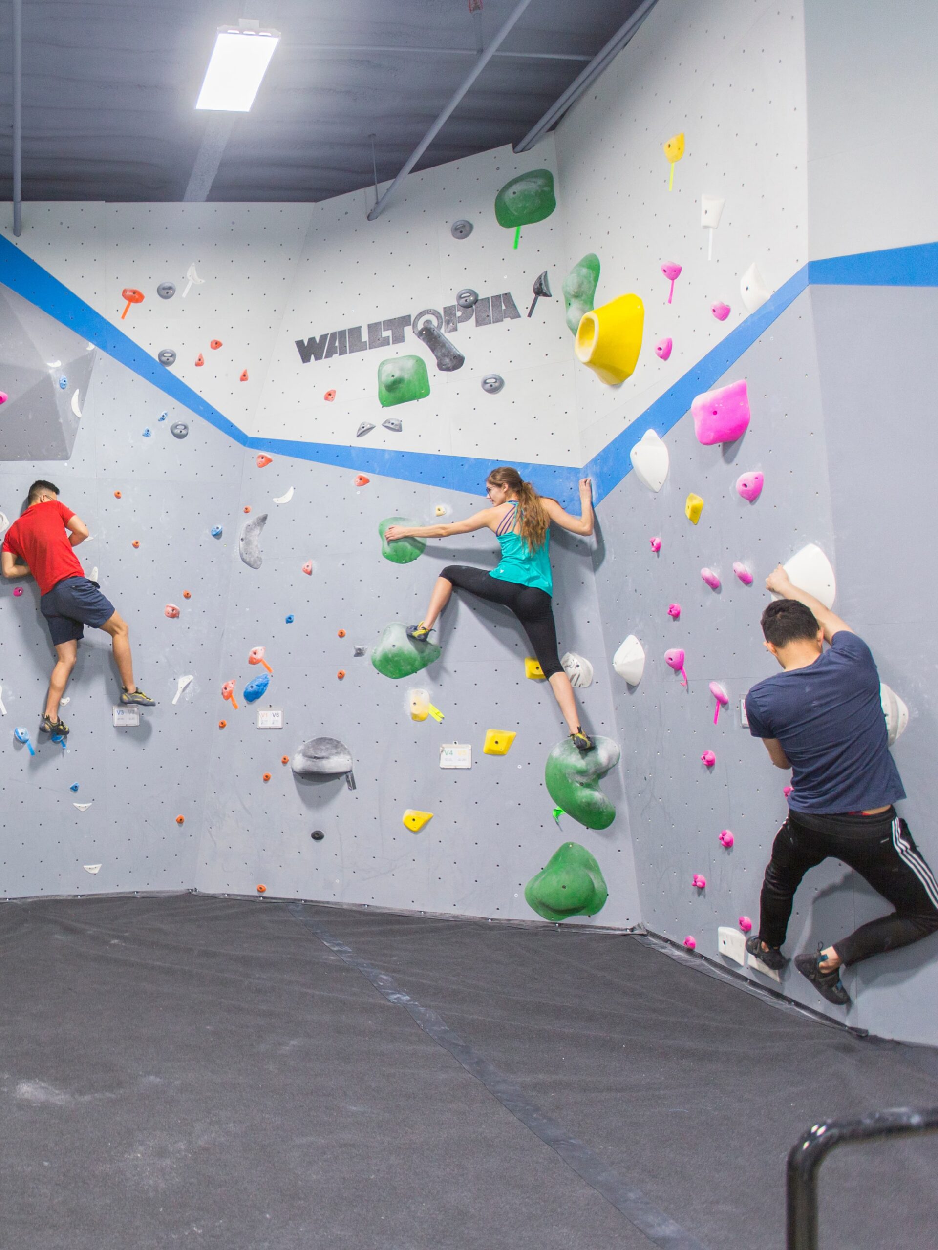 three people are bouldering at central rock gym