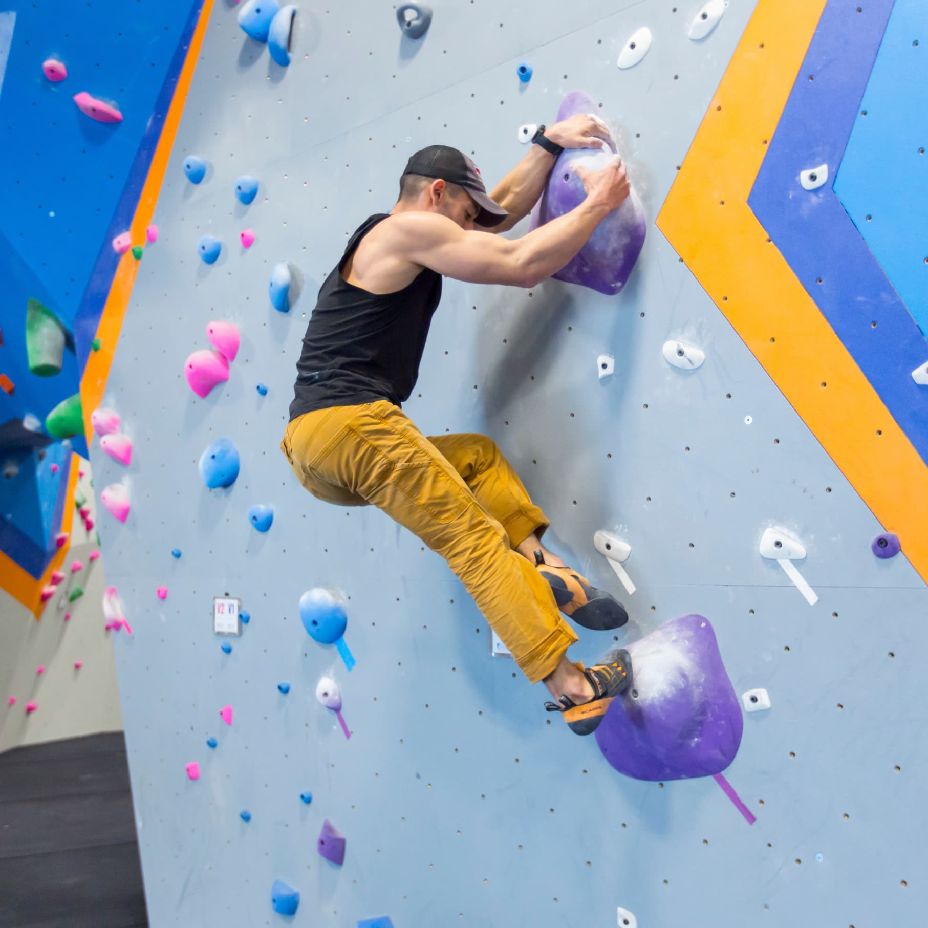 A man is bouldering at central rock gym