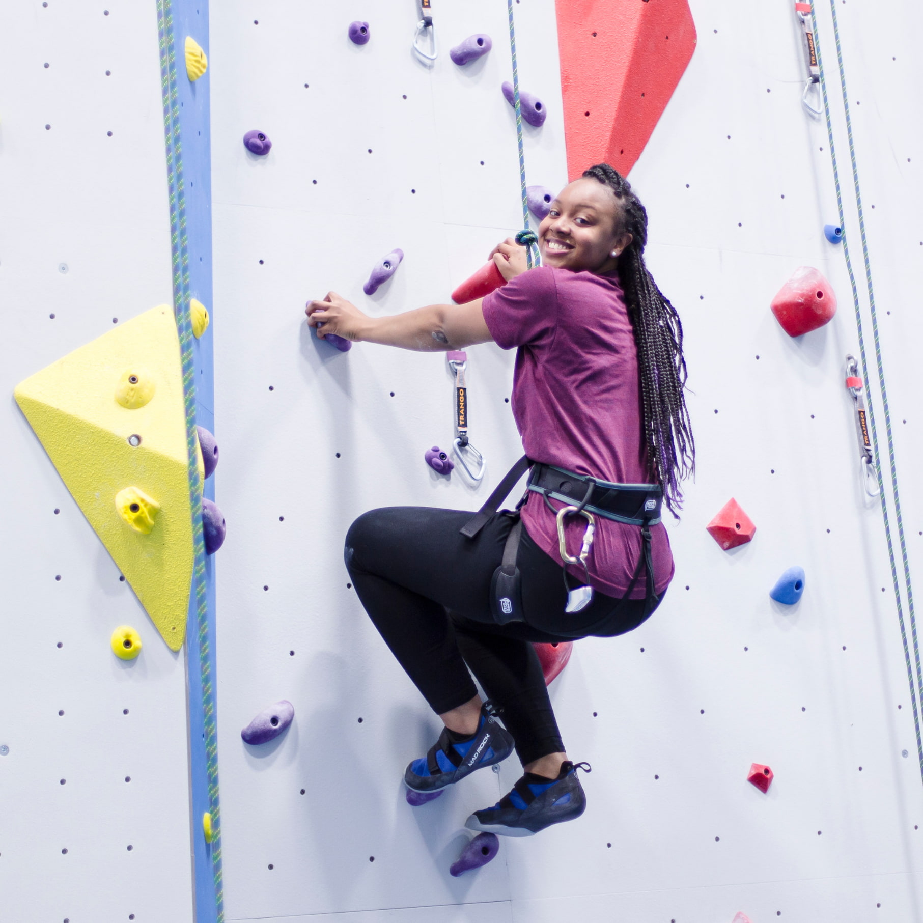 A girl is top rope climbing at central rock gym