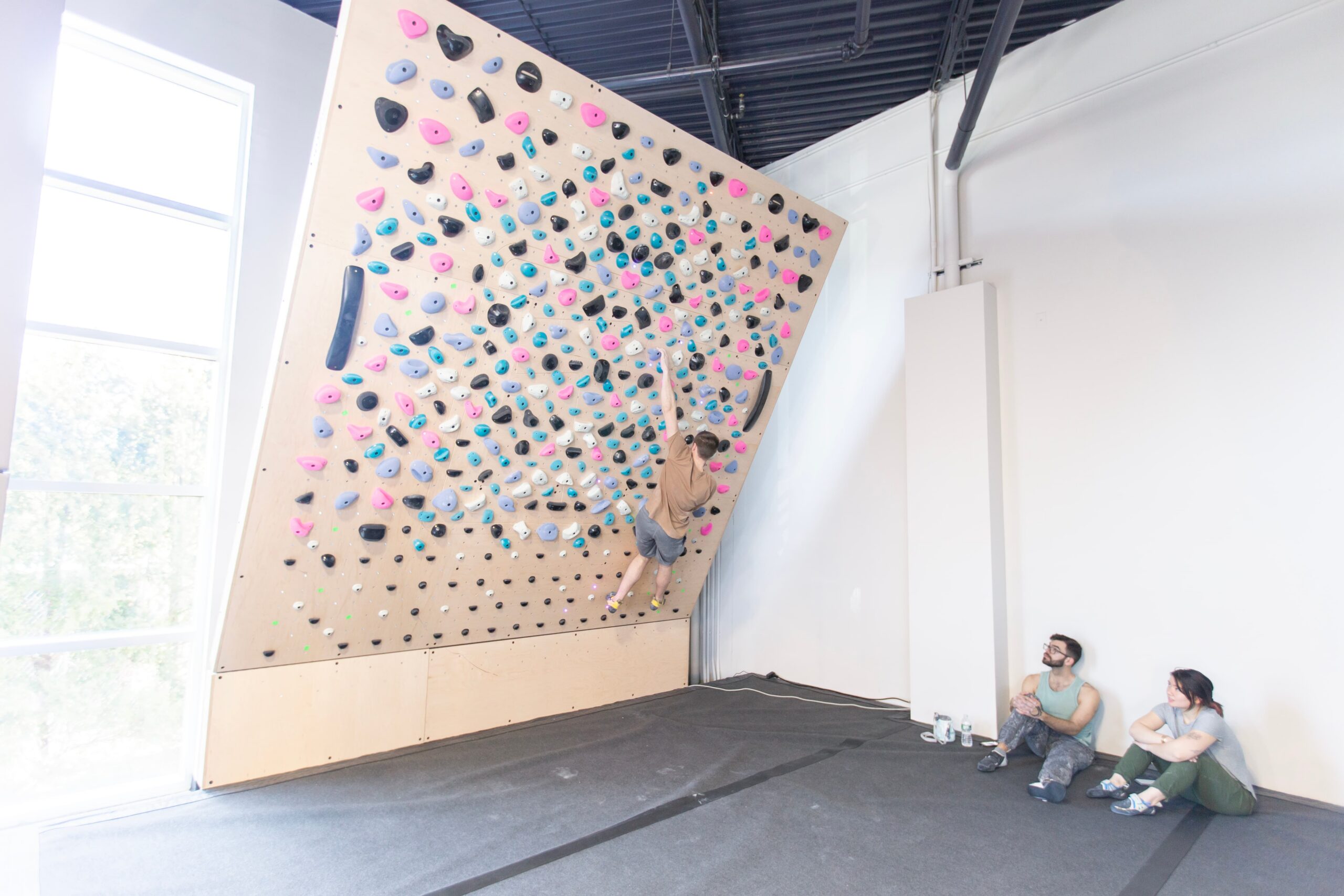 A man is bouldering at central rock gym